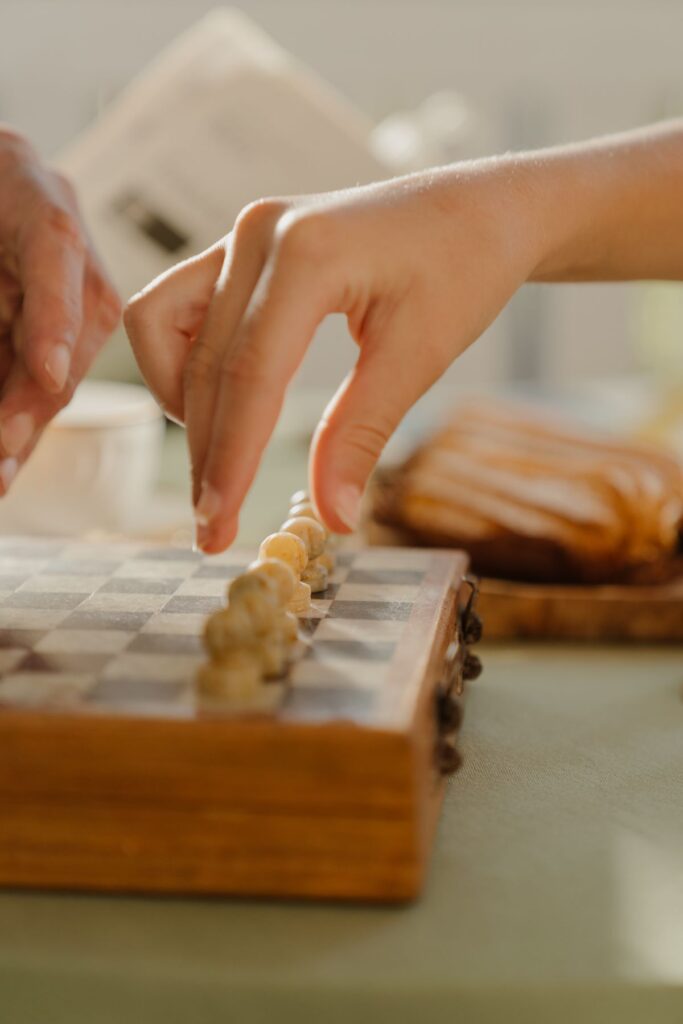 Hand moving a chess piece representing a gambit pawn sacrifice strategy
