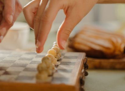 Hand moving a chess piece representing a gambit pawn sacrifice strategy